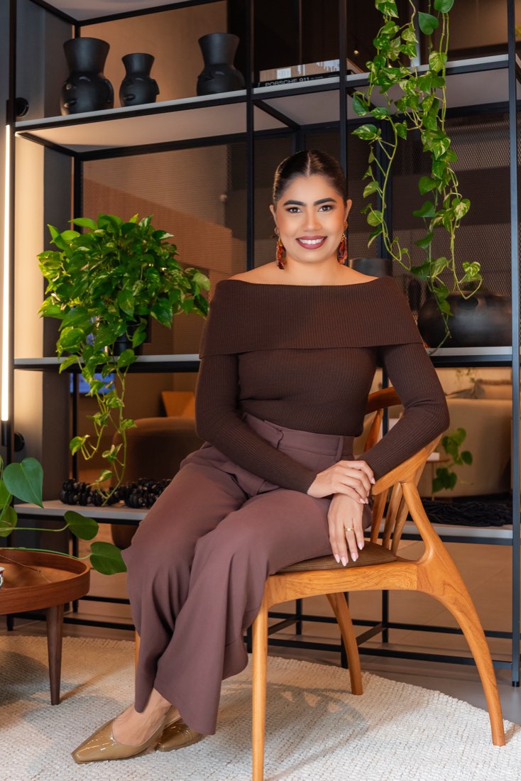 Juliana Oliveira sentada em um ambiente de trabalho
